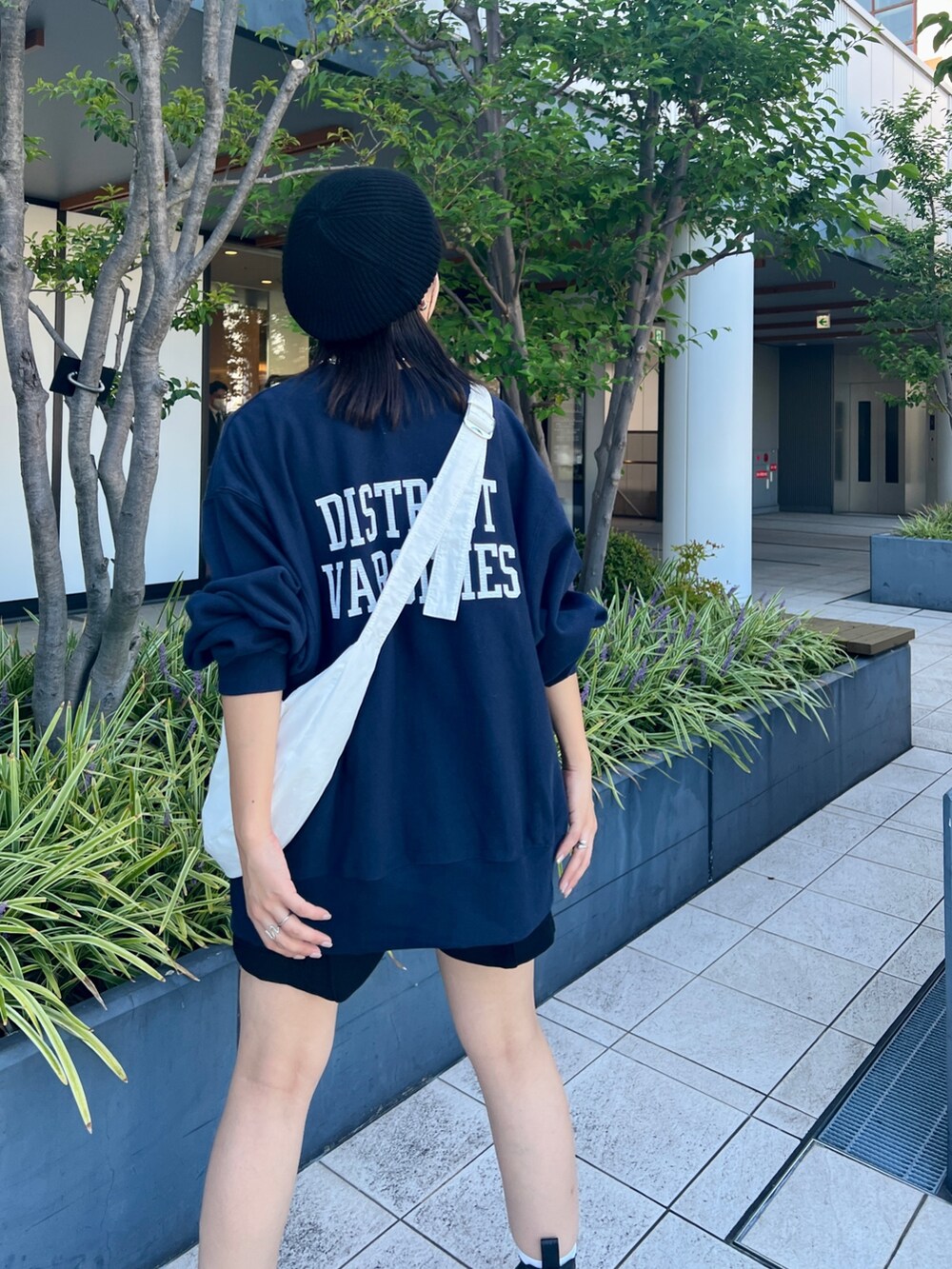 ブルー系のスウェット、ホワイト系のショルダーバッグ、ブラック系のハンチング/ベレー帽を着用したレディースの秋コーディネートの2枚目の写真