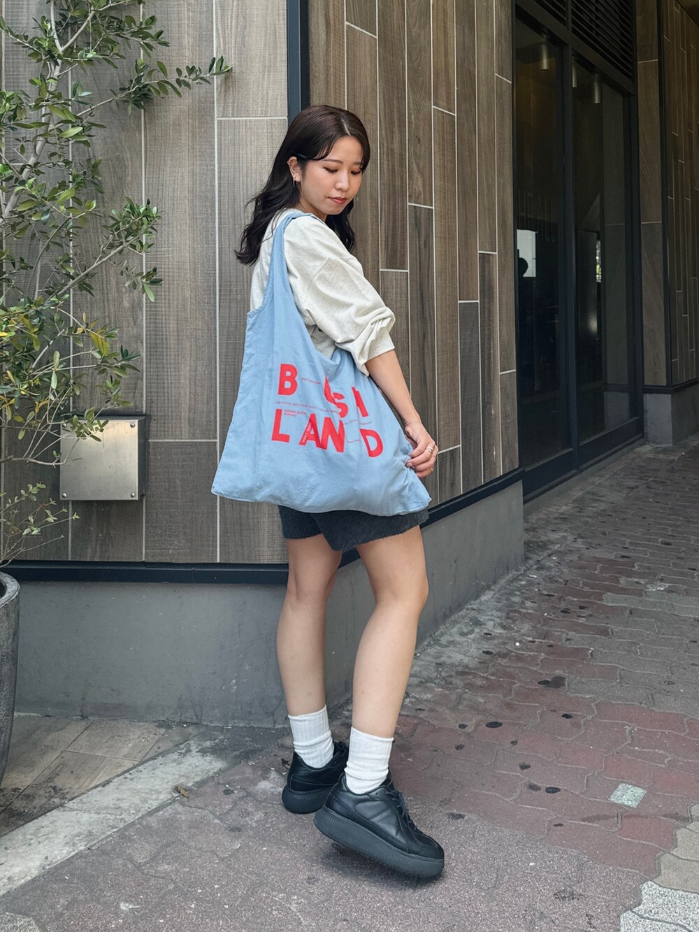 グレー系のその他パンツ、グレー系のスウェット、ブルー系のエコバッグ/サブバッグを着用したレディースの夏コーディネートの2枚目の写真