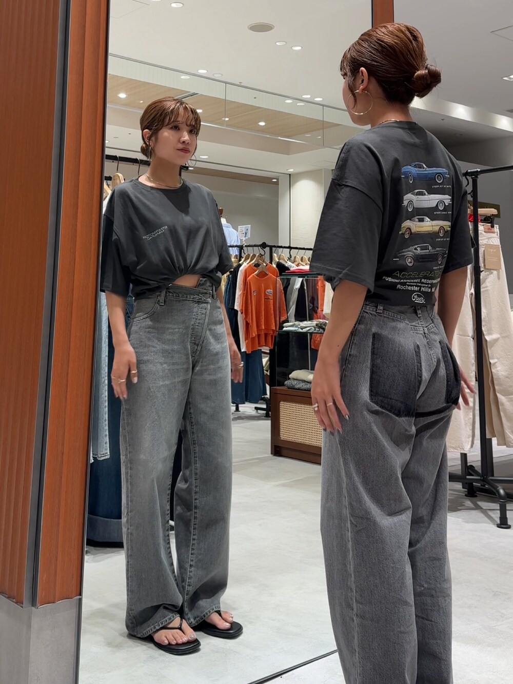 ブラック系のデニムパンツ、グレー系のTシャツ/カットソー、ブラック系のサンダルを着用したレディースの夏コーディネートの3枚目の写真