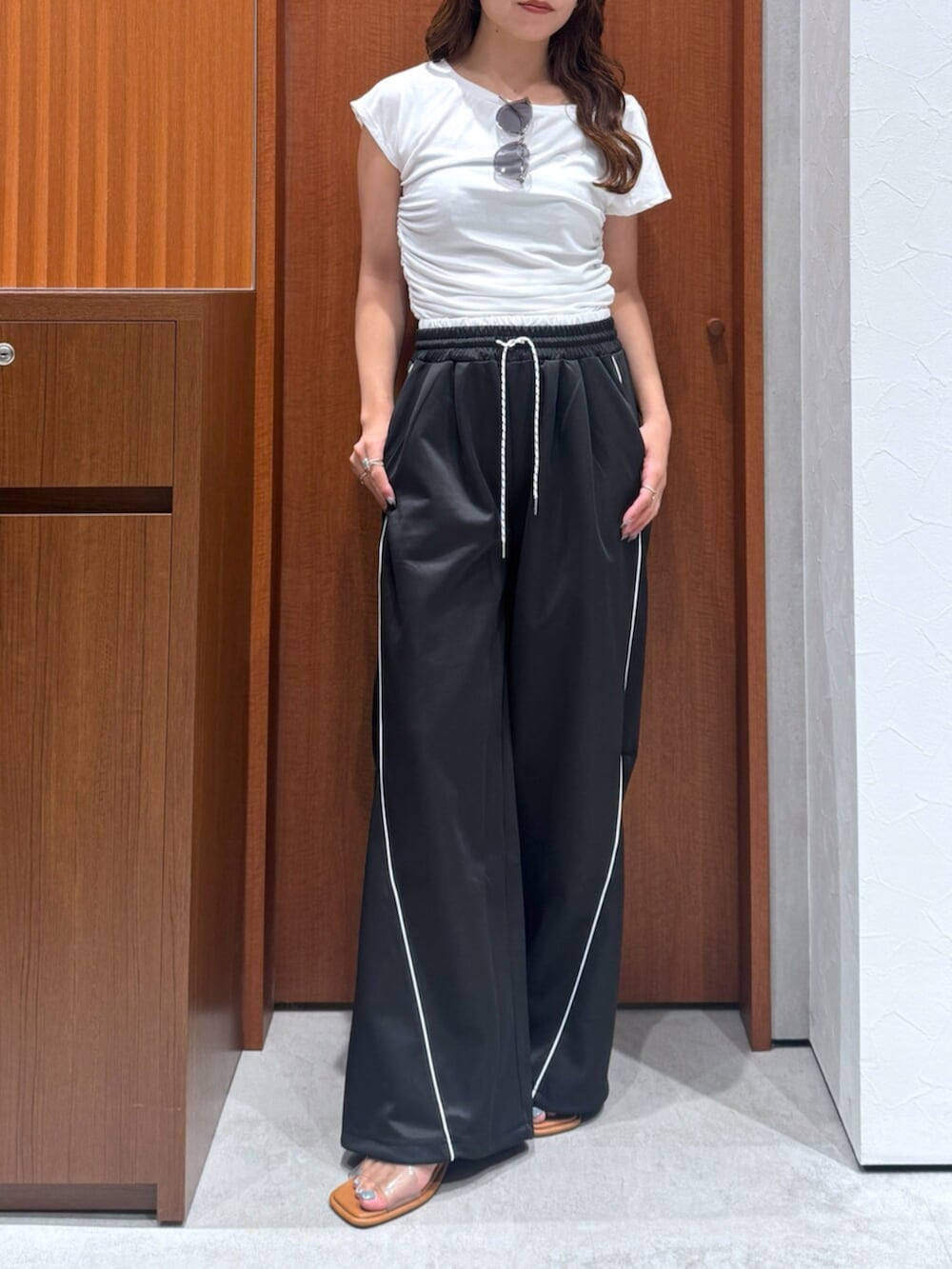 ブラック系のその他パンツ、ホワイト系のTシャツ/カットソー、グレー系のサングラスを着用したレディースの夏コーディネートの5枚目の写真