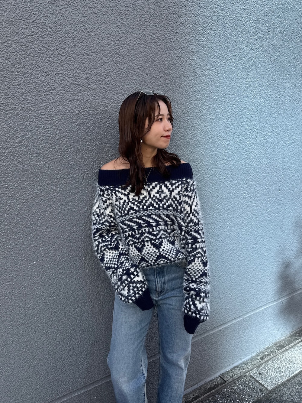 ブルー系のニット/セーター、ブルー系のデニムパンツを着用したレディースの秋コーディネートの9枚目の写真