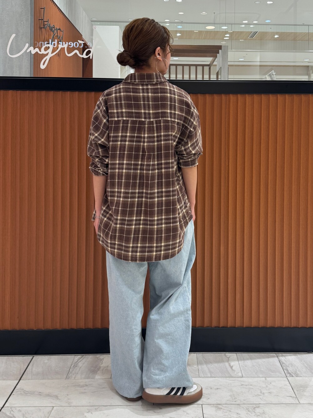 ホワイト系のTシャツ/カットソー、ブラウン系のシャツ/ブラウス、ブルー系のデニムパンツを着用したレディースの冬コーディネートの4枚目の写真