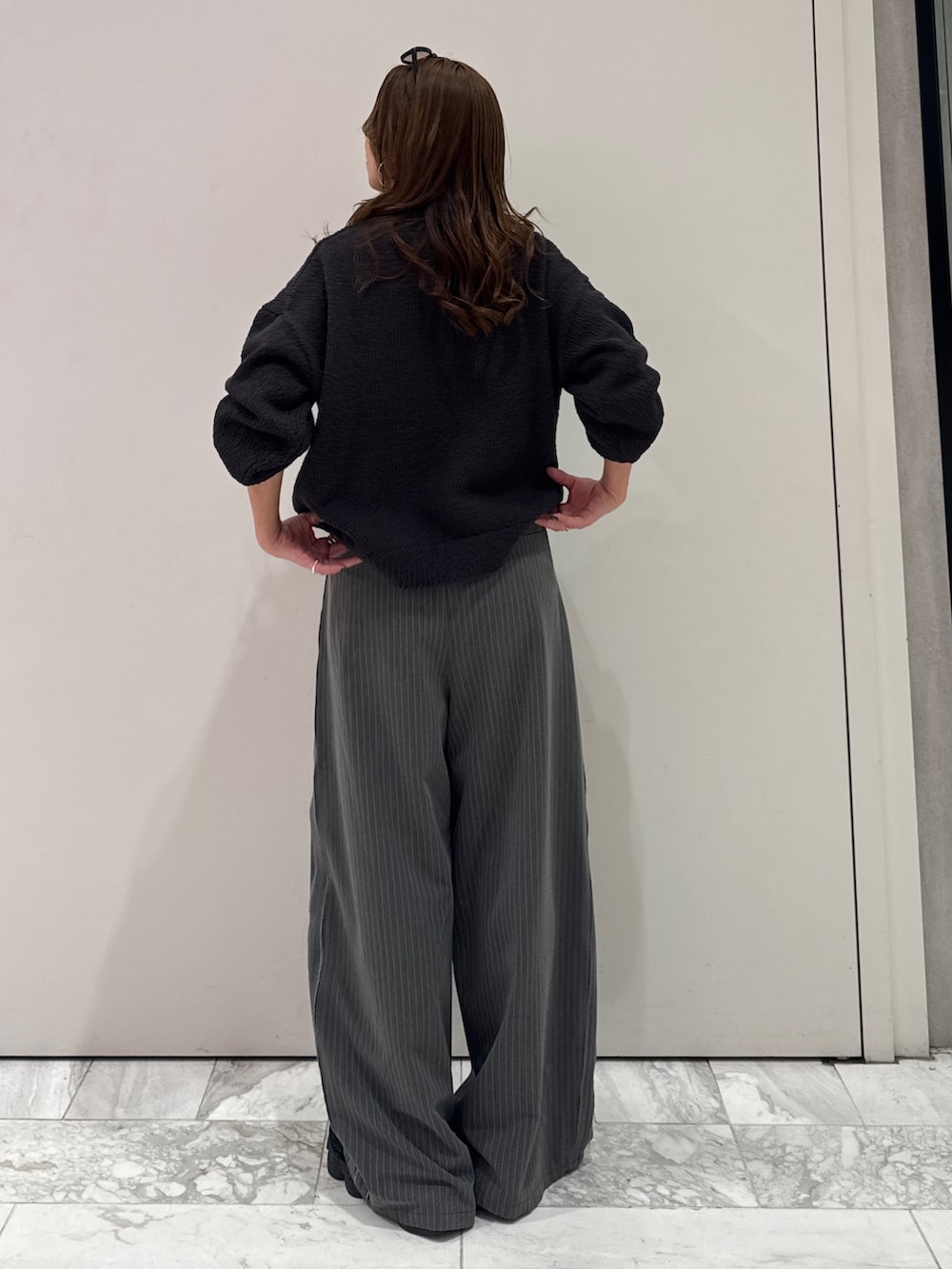 グレー系のその他パンツ、グレー系のニット/セーター、ブルー系のTシャツ/カットソーを着用したレディースの冬コーディネートの6枚目の写真