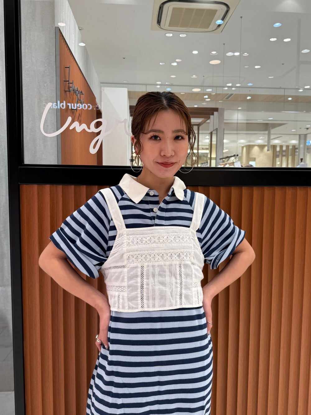 ホワイト系のキャミソール、ブルー系のワンピース、ブラック系のスニーカーを着用したレディースの春コーディネートの8枚目の写真