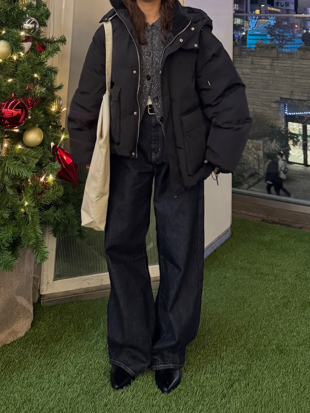 グレー系のカーディガン/ボレロ、ブラック系のダウンジャケット/コート、ホワイト系のトートバッグを着用したレディースの冬コーディネートの4枚目の写真