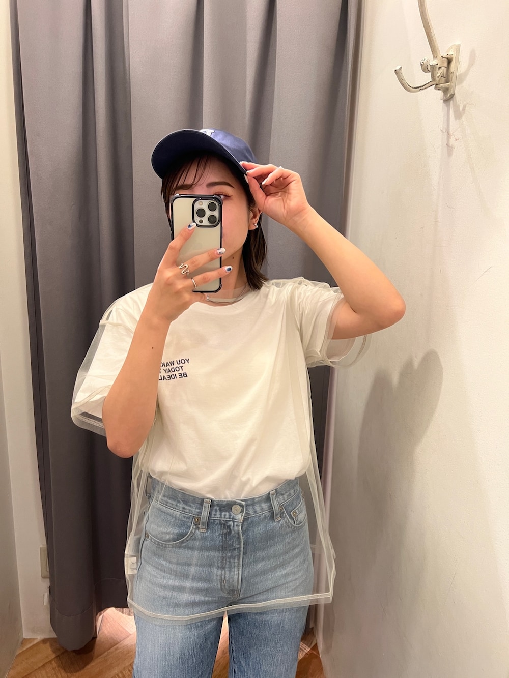 ブルー系のデニムパンツ、ブラック系のサンダル、ホワイト系のTシャツ/カットソーを着用したレディースの春コーディネートの5枚目の写真