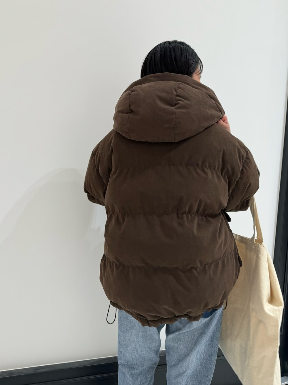 ブルー系のデニムパンツ、ホワイト系のトートバッグ、ホワイト系のTシャツ/カットソーを着用したレディースの冬コーディネートの5枚目の写真