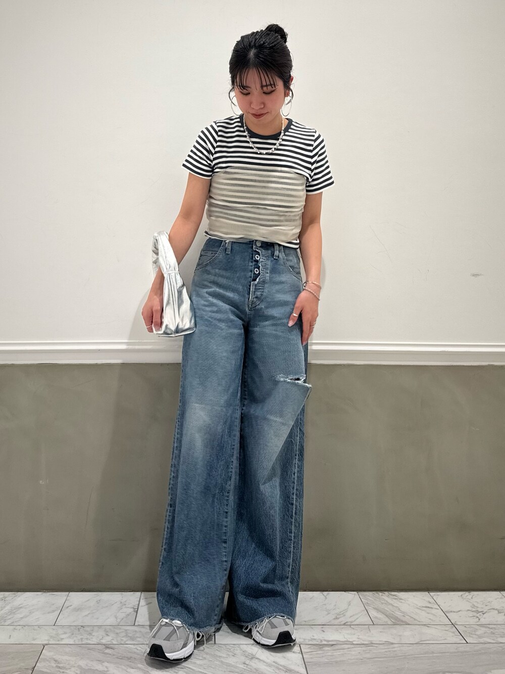 グレー系のTシャツ/カットソー、ベージュ系のキャミソール、ブルー系のデニムパンツを着用したレディースの春コーディネートの7枚目の写真