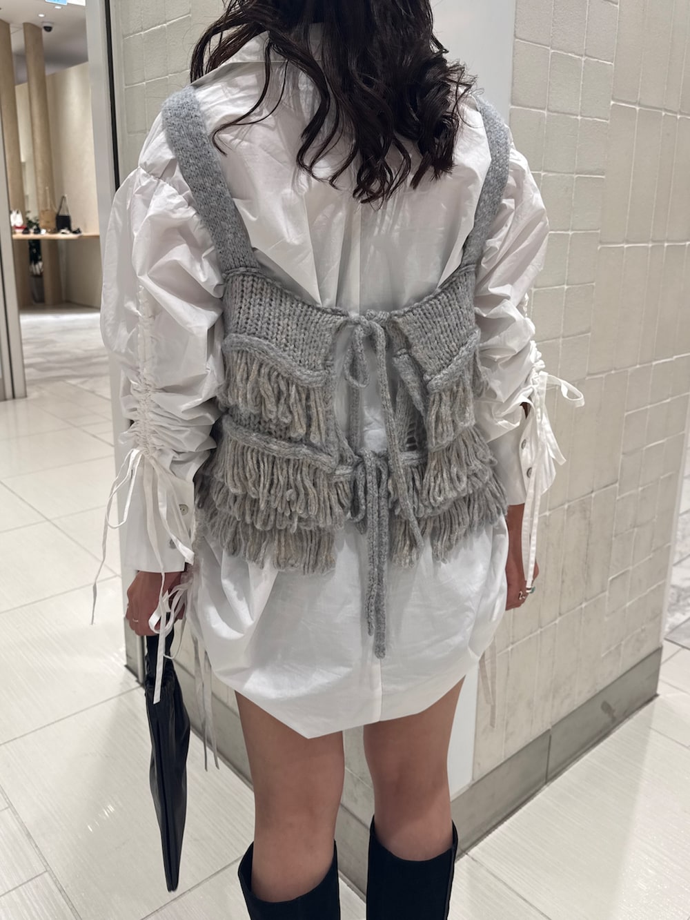 ホワイト系のシャツ/ブラウス、ブルー系のニット/セーター、ブラック系のショルダーバッグを着用したレディースの秋コーディネートの6枚目の写真