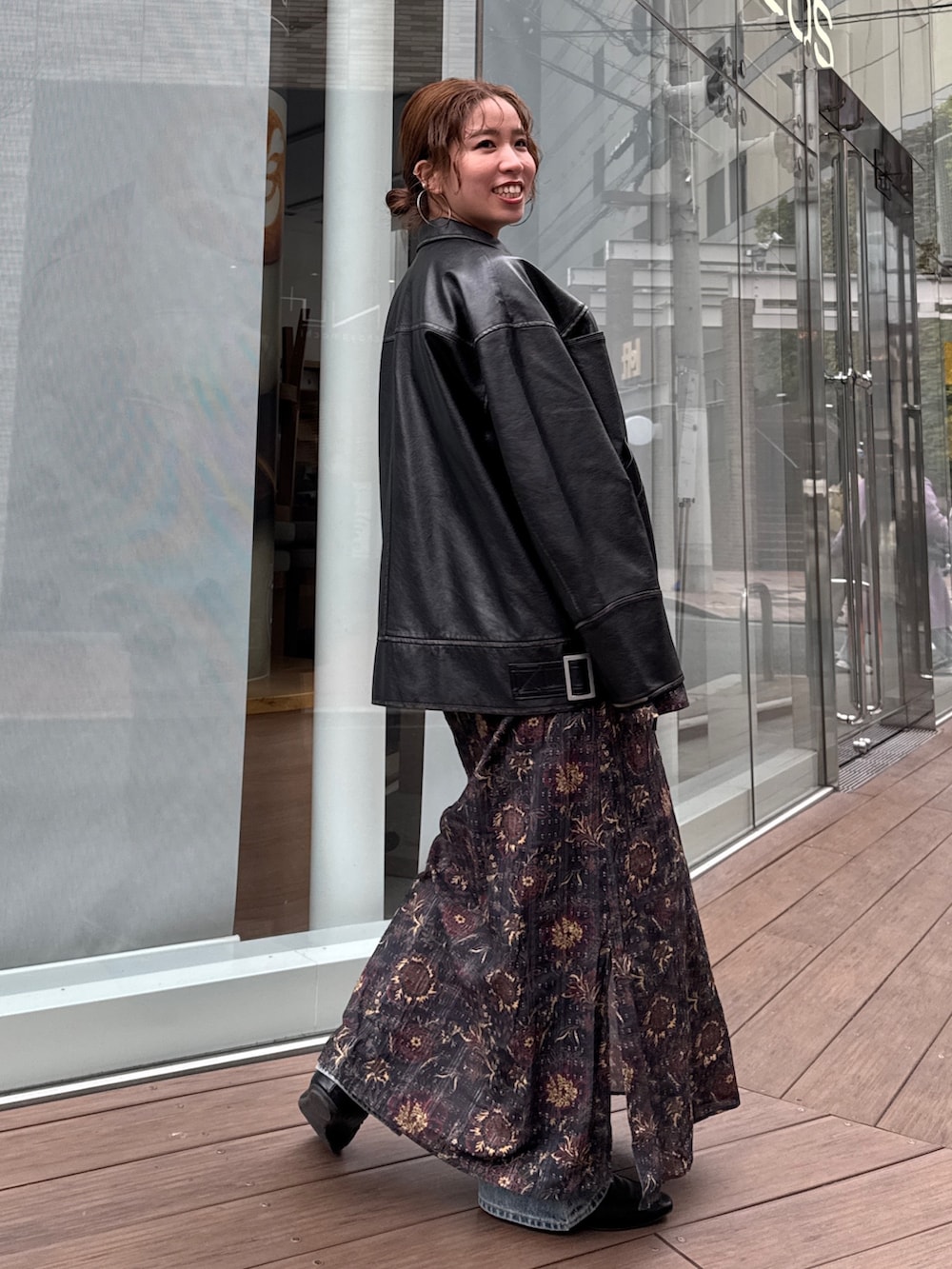 ブラック系のブルゾン、ブラック系のワンピース、ブルー系のデニムパンツを着用したレディースの冬コーディネートの5枚目の写真