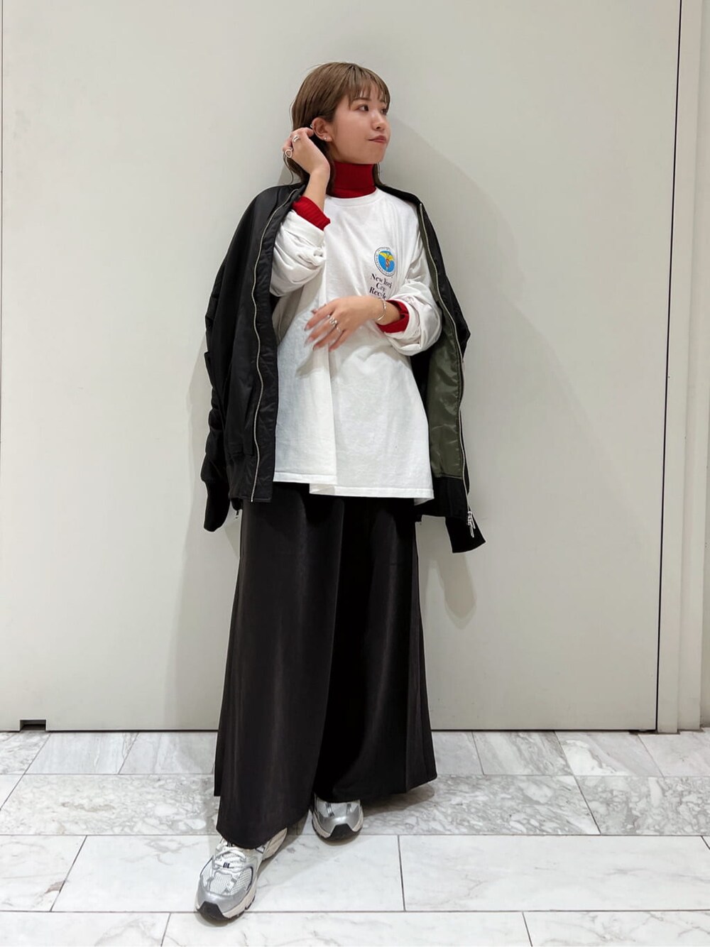 ブラック系のスカート、ブラック系のMA-1、レッド系のニット/セーターを着用したレディースの秋コーディネートの2枚目の写真