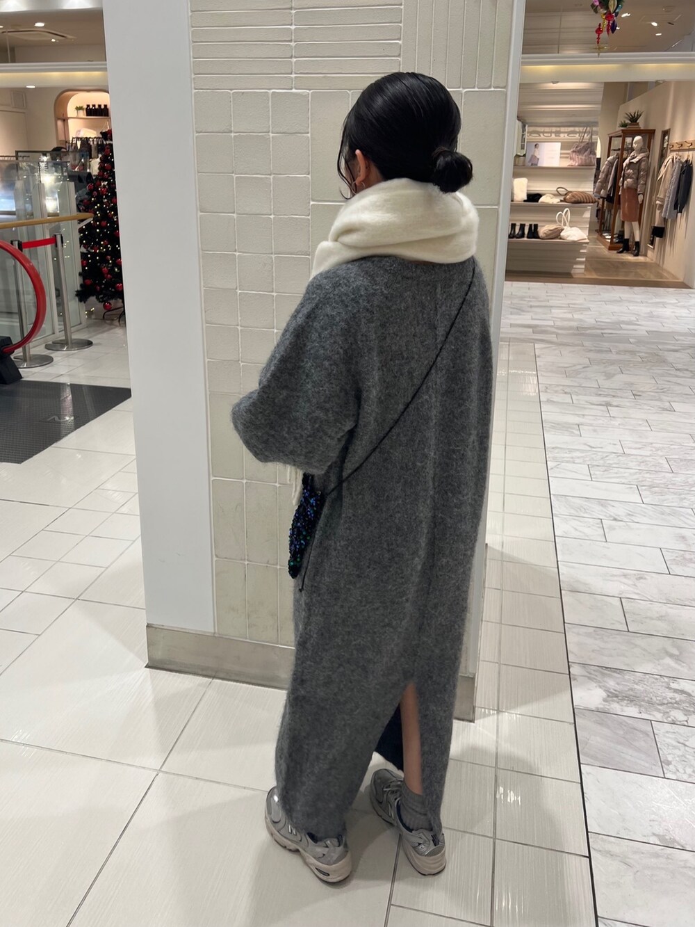 グレー系のワンピース、グリーン系のショルダーバッグ、ホワイト系のマフラーを着用したレディースの秋コーディネートの7枚目の写真