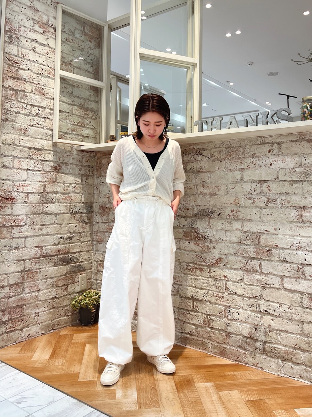 ホワイト系のカーゴパンツ、ホワイト系のカーディガン/ボレロ、ホワイト系のスニーカーを着用したレディースの春コーディネートの3枚目の写真