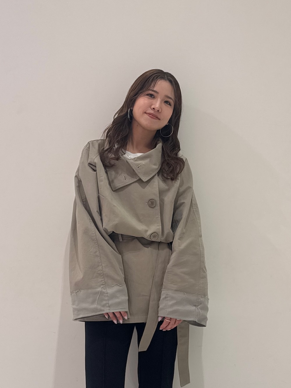 グリーン系のトレンチコート、ブラック系のその他パンツ、ブラック系のパンプスを着用したレディースの春コーディネートの6枚目の写真