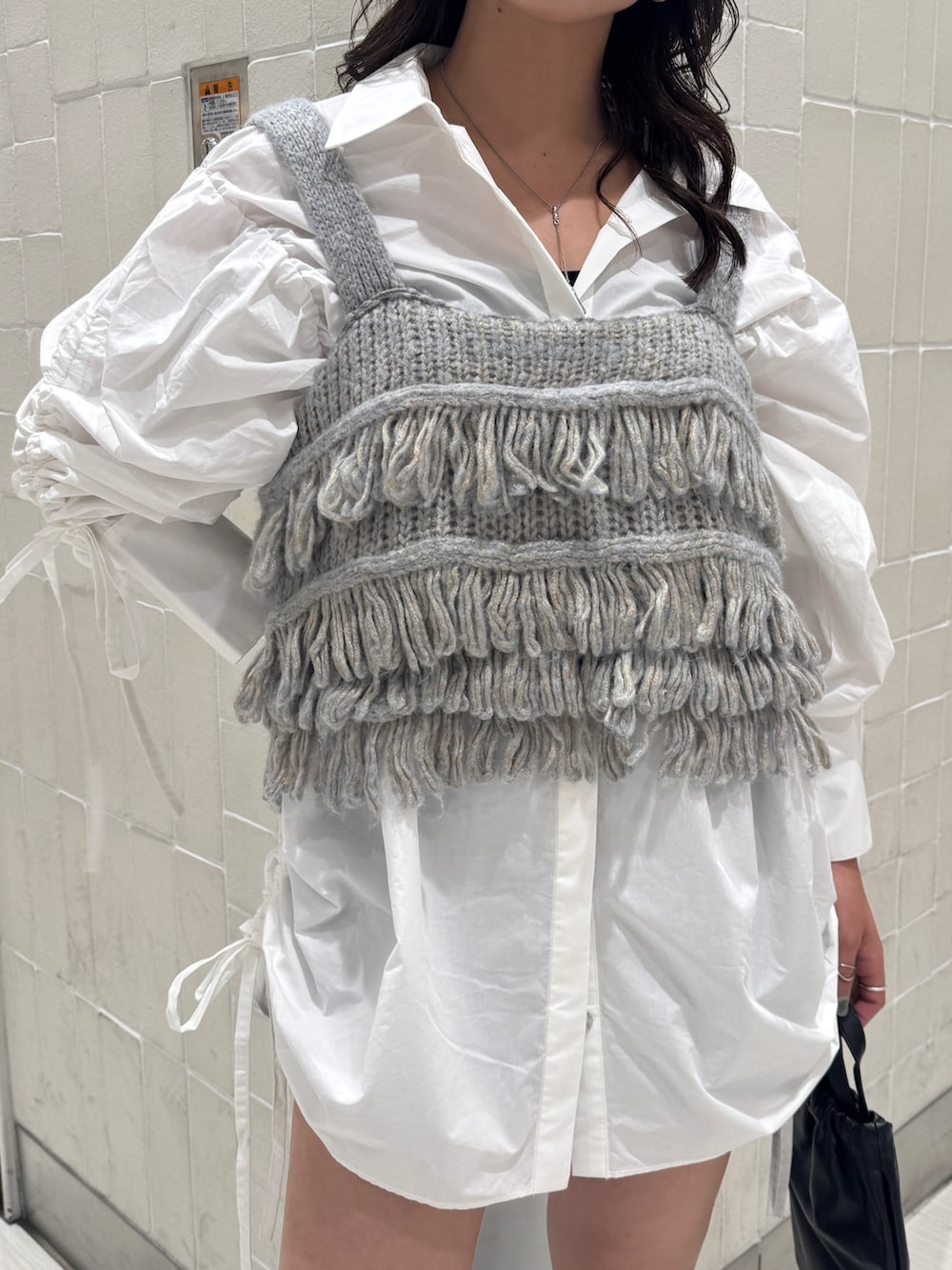 ホワイト系のシャツ/ブラウス、ブルー系のニット/セーター、ブラック系のショルダーバッグを着用したレディースの秋コーディネートの9枚目の写真