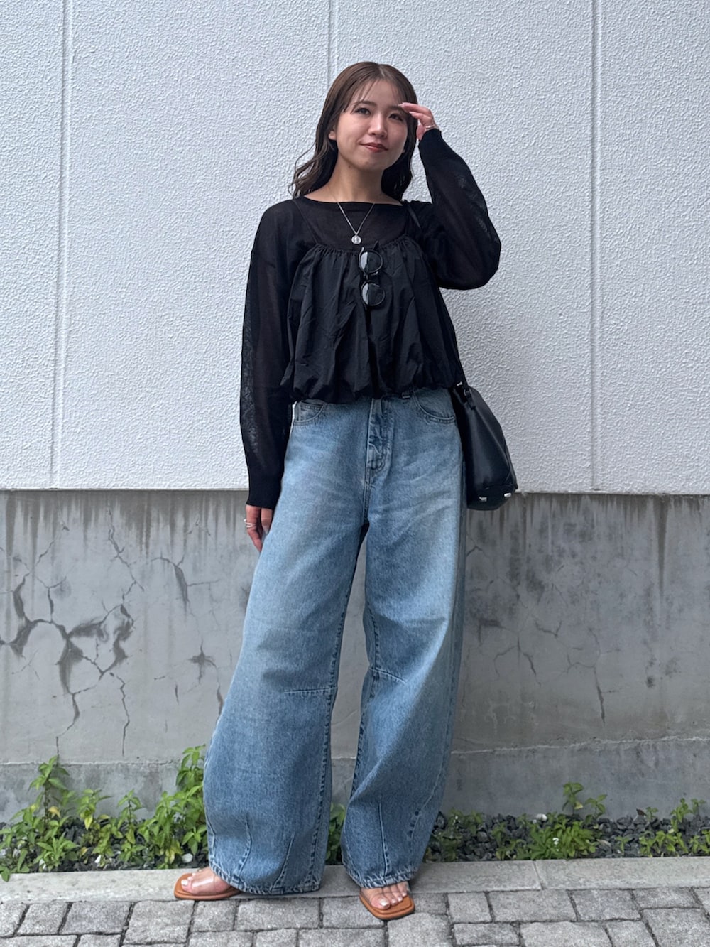 ブルー系のデニムパンツ、ブラック系のキャミソール、ブラック系のニット/セーターを着用したレディースの夏コーディネートの2枚目の写真