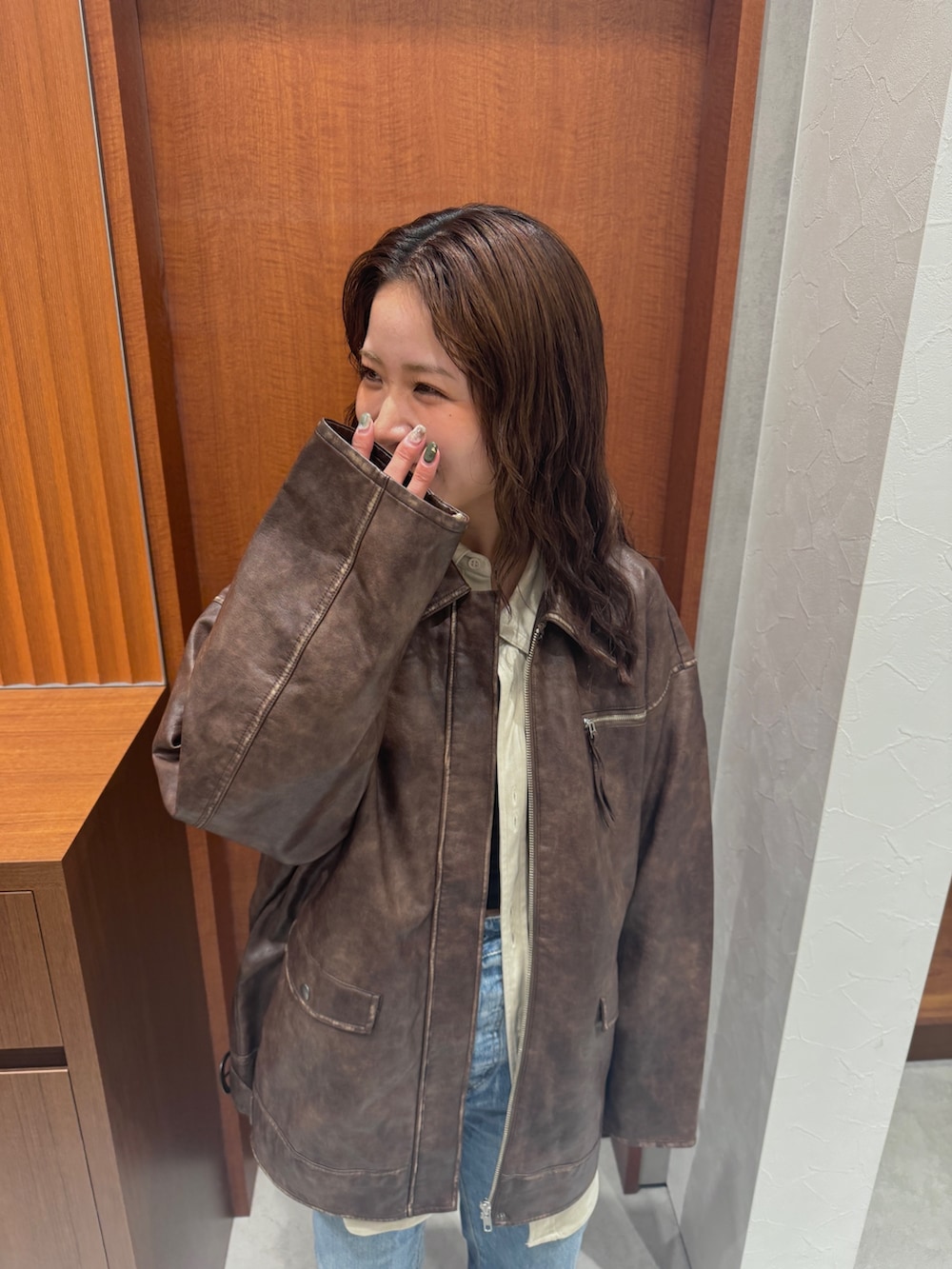 ブラウン系のブルゾン、ホワイト系のシャツ/ブラウス、ブルー系のデニムパンツを着用したレディースの秋コーディネートの7枚目の写真