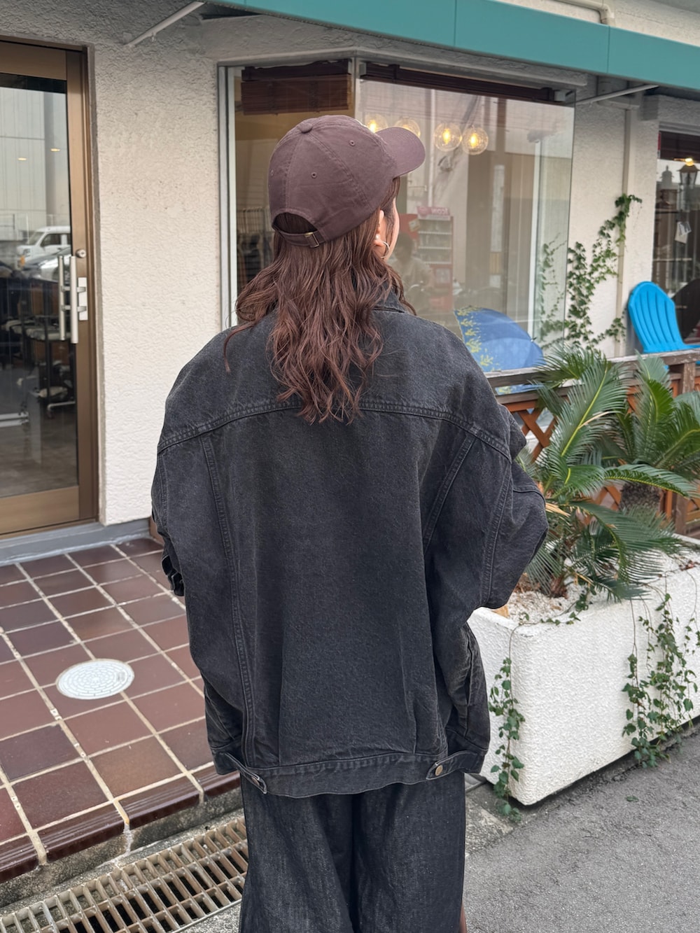 ブラック系のデニムジャケット、ブラック系のデニムパンツ、ブラウン系のトートバッグを着用したレディースの秋コーディネートの7枚目の写真