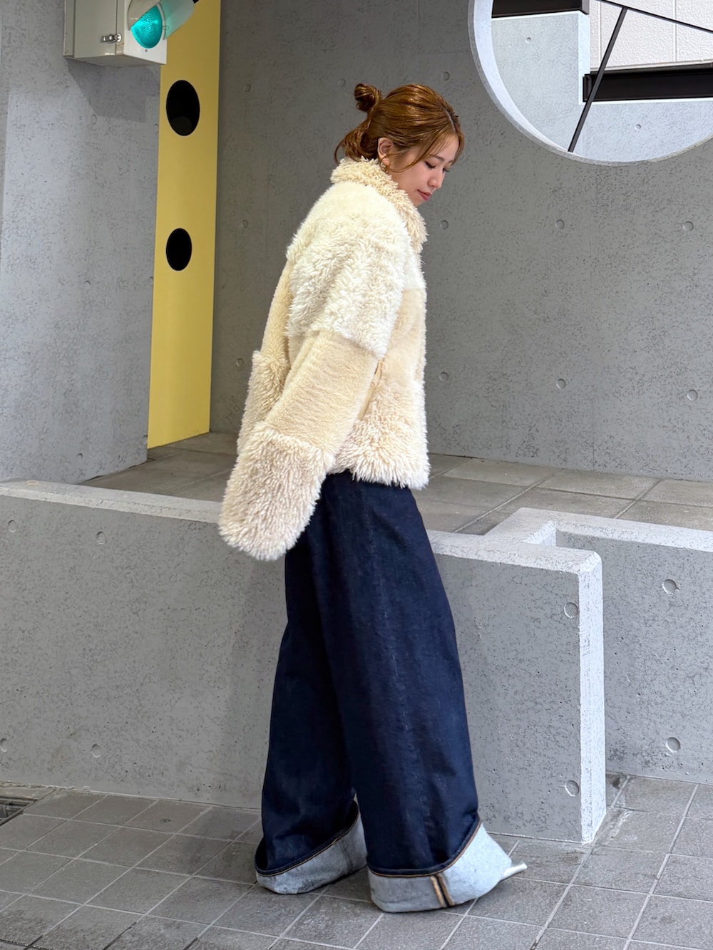ホワイト系のブルゾン、シルバー系のパンプス、ブルー系のデニムパンツを着用したレディースの秋コーディネートの3枚目の写真