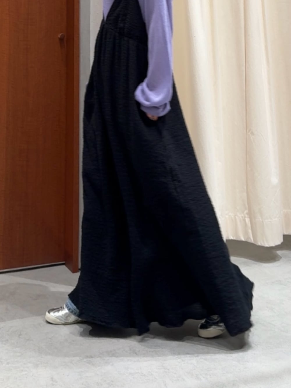 ブラック系のワンピース、パープル系のニット/セーター、ブルー系のデニムパンツを着用したレディースの春コーディネートの3枚目の写真