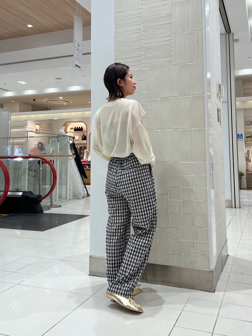 イエロー系のニット/セーター、イエロー系のパンプス、グレー系のその他パンツを着用したレディースの冬コーディネートの4枚目の写真