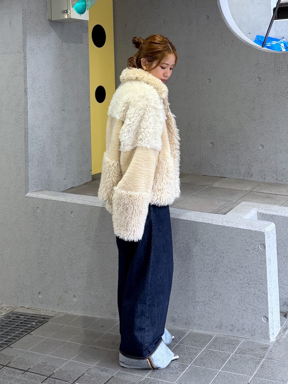 ホワイト系のブルゾン、シルバー系のパンプス、ブルー系のデニムパンツを着用したレディースの秋コーディネートの6枚目の写真
