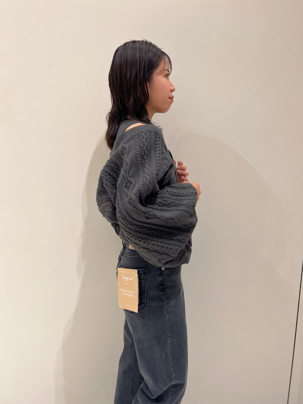 グレー系のカーディガン/ボレロ、ブラック系のデニムパンツ、ブラック系のブーツを着用したレディースの秋コーディネートの2枚目の写真