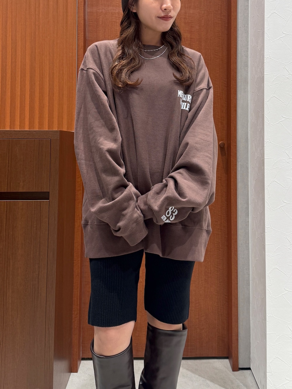 ベージュ系のトレンチコート、ブラウン系のスウェット、ブラック系のその他パンツを着用したレディースの秋コーディネートの10枚目の写真