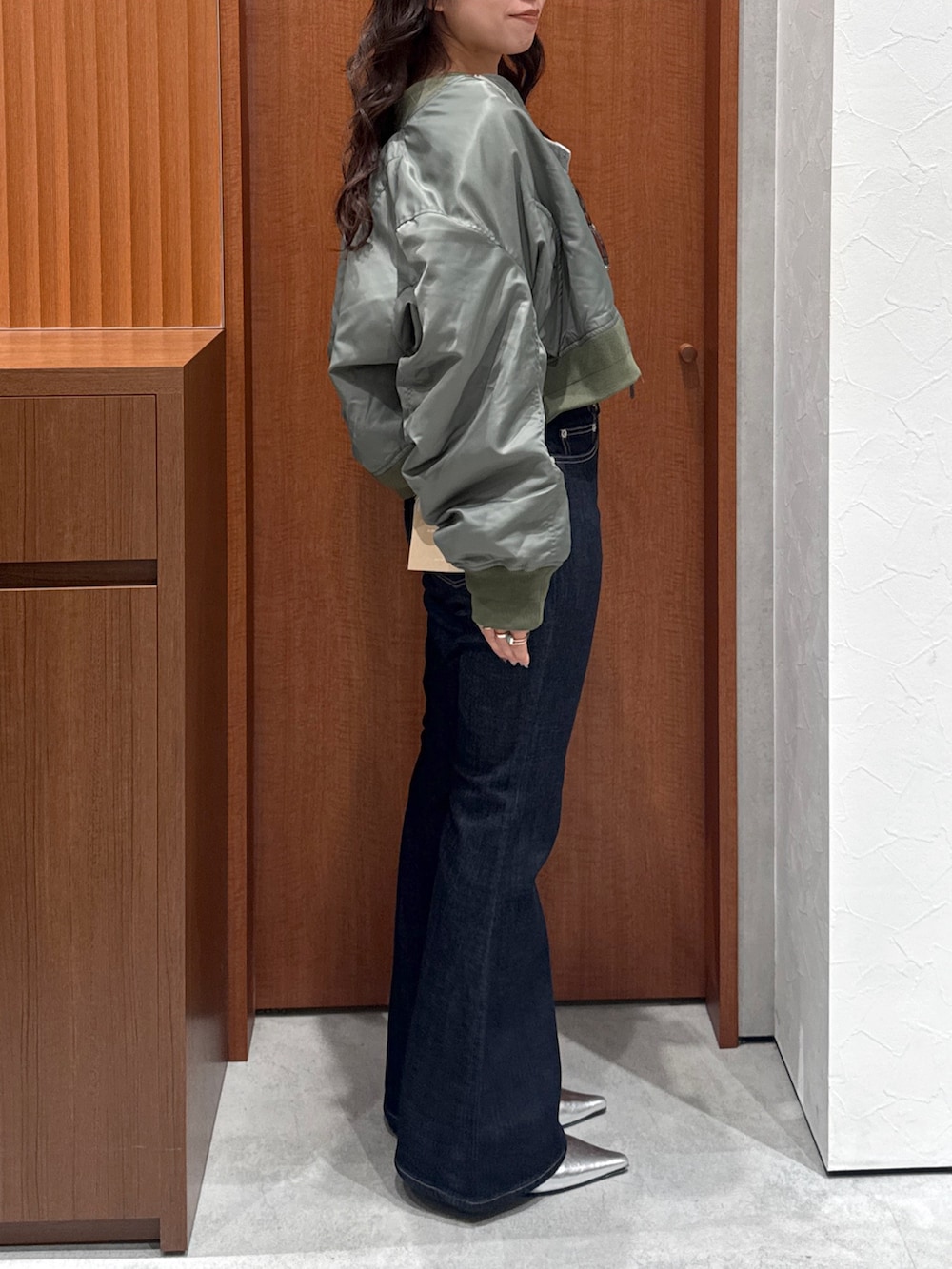 ブルー系のデニムパンツ、グレー系のTシャツ/カットソー、グリーン系のMA-1を着用したレディースの秋コーディネートの3枚目の写真