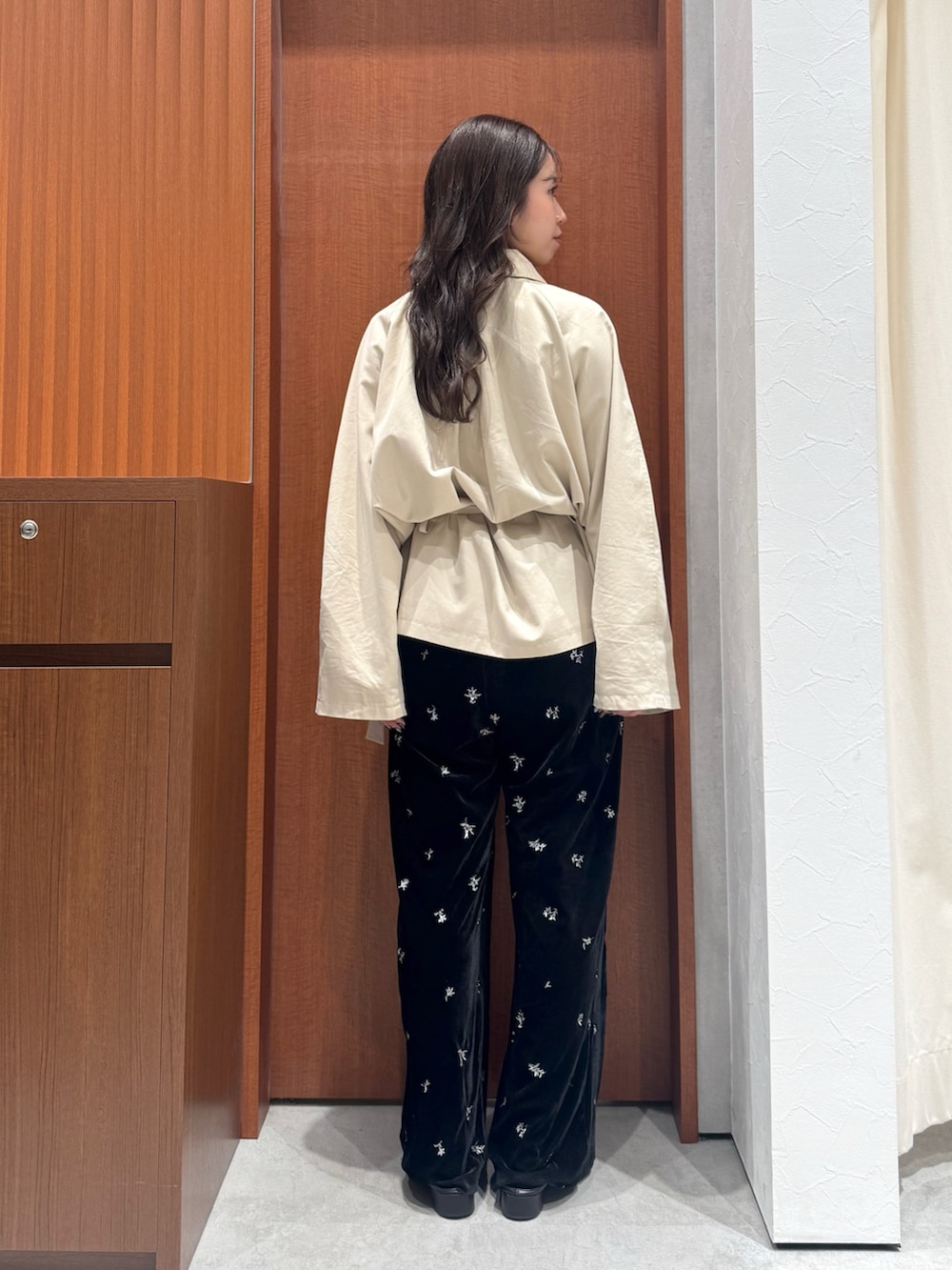 ブラック系のその他パンツ、ベージュ系のトレンチコート、ブラック系のサンダルを着用したレディースの秋コーディネートの4枚目の写真