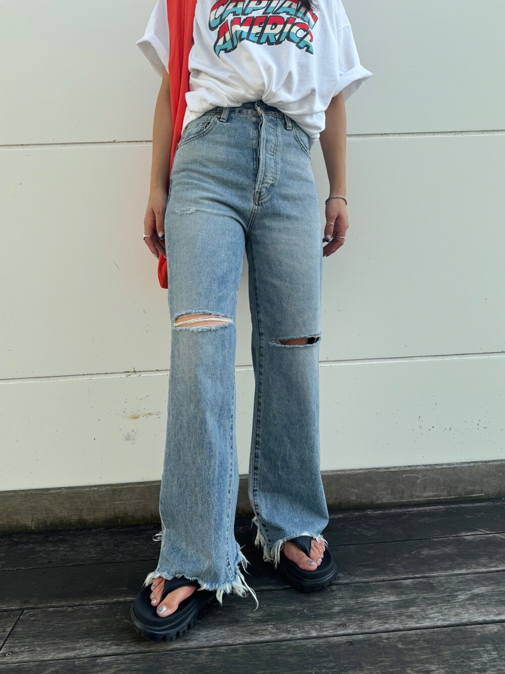 ブルー系のデニムパンツ、ホワイト系のTシャツ/カットソー、オレンジ系のエコバッグ/サブバッグを着用したレディースの夏コーディネートの6枚目の写真