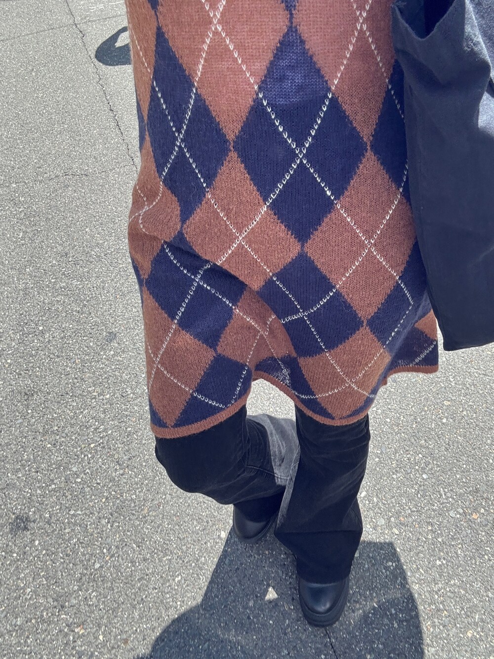 ブラウン系のニット/セーター、ブラック系のデニムパンツ、ブラウン系のハンドバッグを着用したレディースの夏コーディネートの7枚目の写真