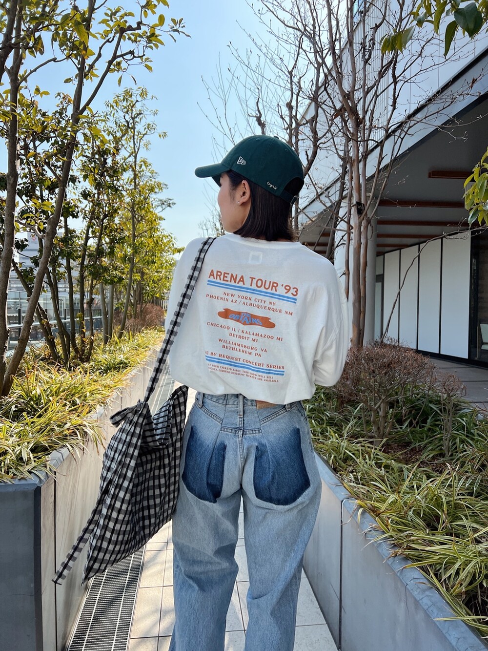 ブルー系のデニムパンツ、ホワイト系のTシャツ/カットソー、グレー系のショルダーバッグを着用したレディースの冬コーディネートの4枚目の写真
