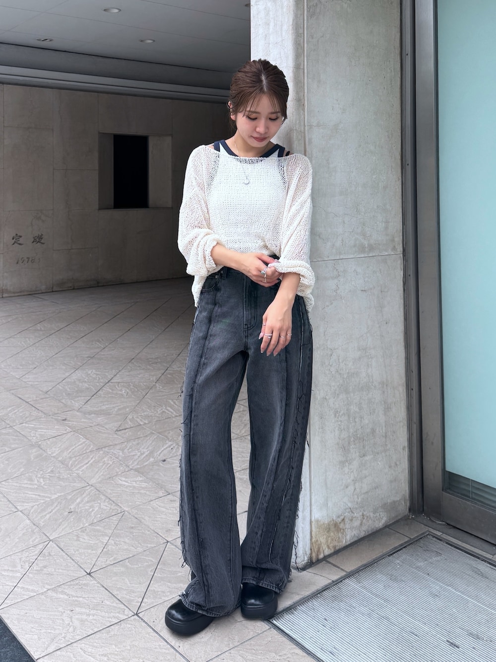 ブラック系のデニムパンツ、ホワイト系のタンクトップ、ホワイト系のニット/セーターを着用したレディースの夏コーディネートの2枚目の写真