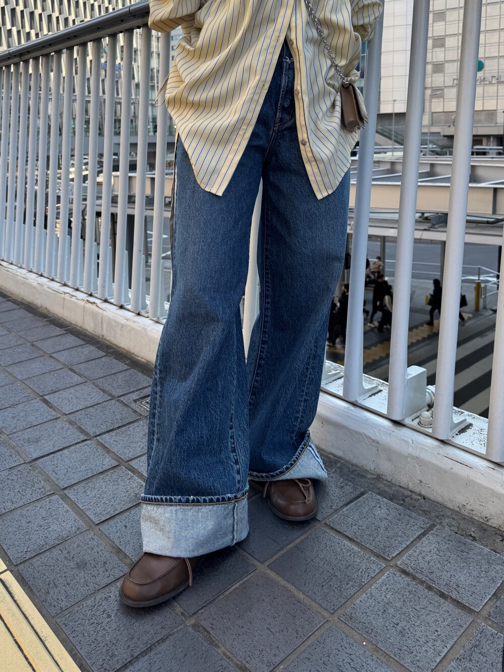 イエロー系のシャツ/ブラウス、ブルー系のデニムパンツ、ブラウン系のローファーを着用したレディースの冬コーディネートの7枚目の写真