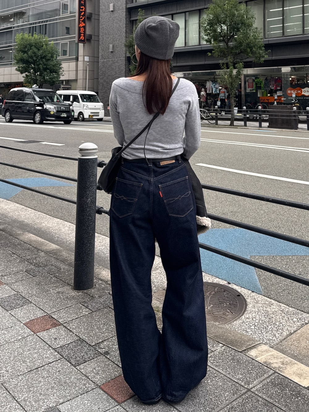 グレー系のニット/セーター、ブルー系のデニムパンツ、グレー系のニットキャップ/ビーニーを着用したレディースの秋コーディネートの4枚目の写真
