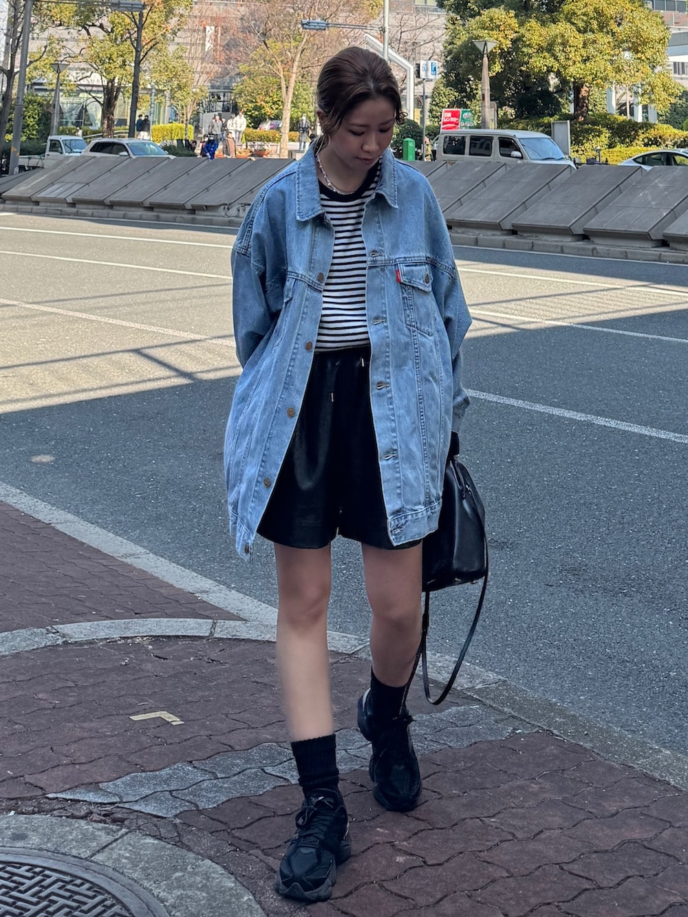 ブルー系のデニムジャケット、ブルー系のTシャツ/カットソー、ブラック系のその他パンツを着用したレディースの冬コーディネートの6枚目の写真