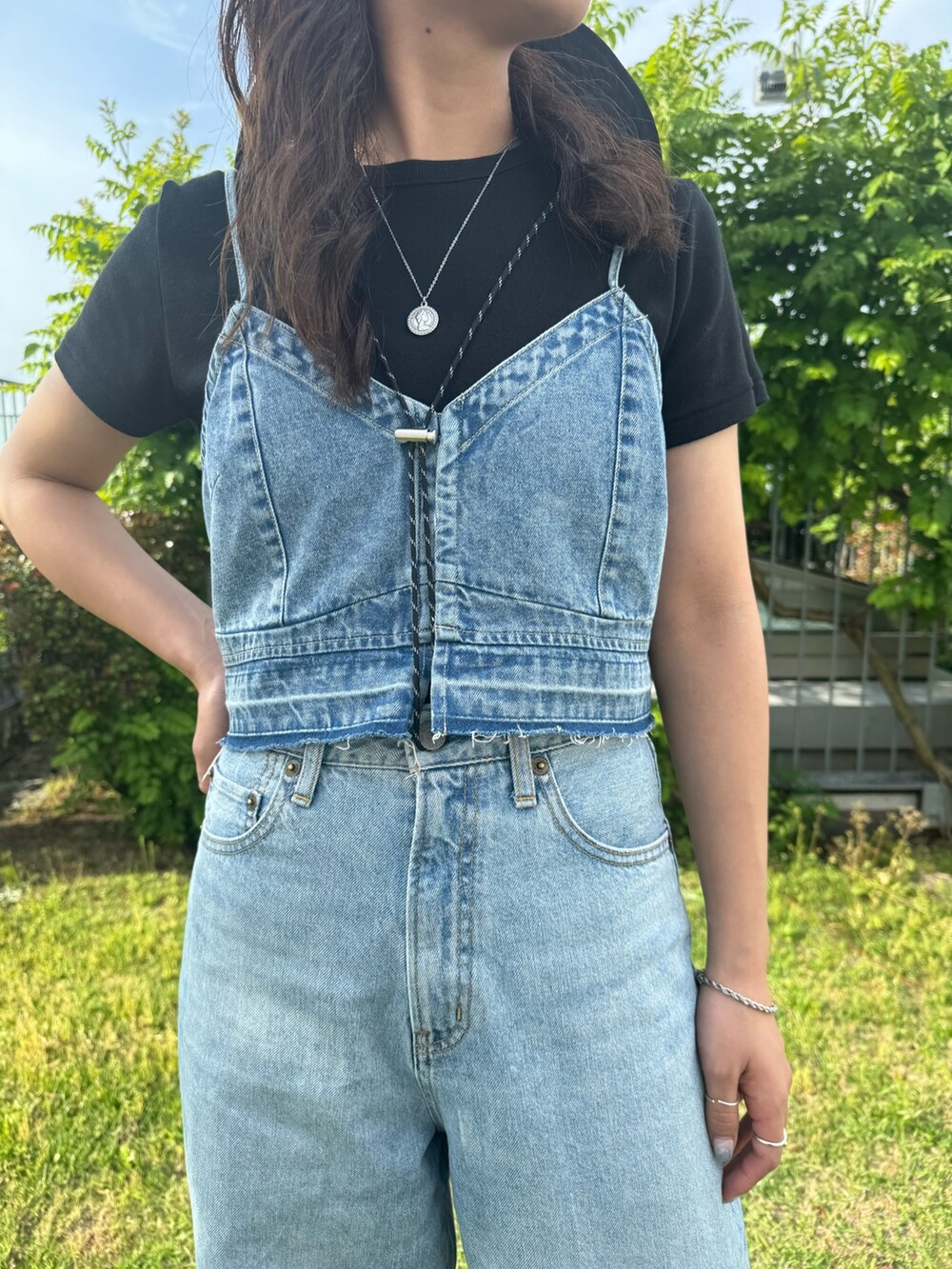 ブルー系のキャミソール、ブルー系のデニムパンツ、ブラック系のTシャツ/カットソーを着用したレディースの夏コーディネートの9枚目の写真