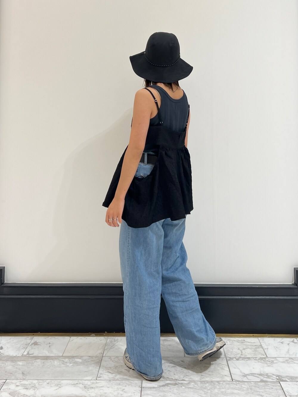 グレー系のタンクトップ、ブルー系のデニムパンツ、ブラック系のシャツ/ブラウスを着用したレディースの春コーディネートの4枚目の写真