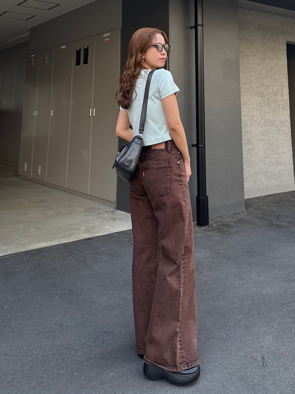 ブラウン系のデニムパンツ、ブルー系のTシャツ/カットソーを着用したレディースの春コーディネートの2枚目の写真