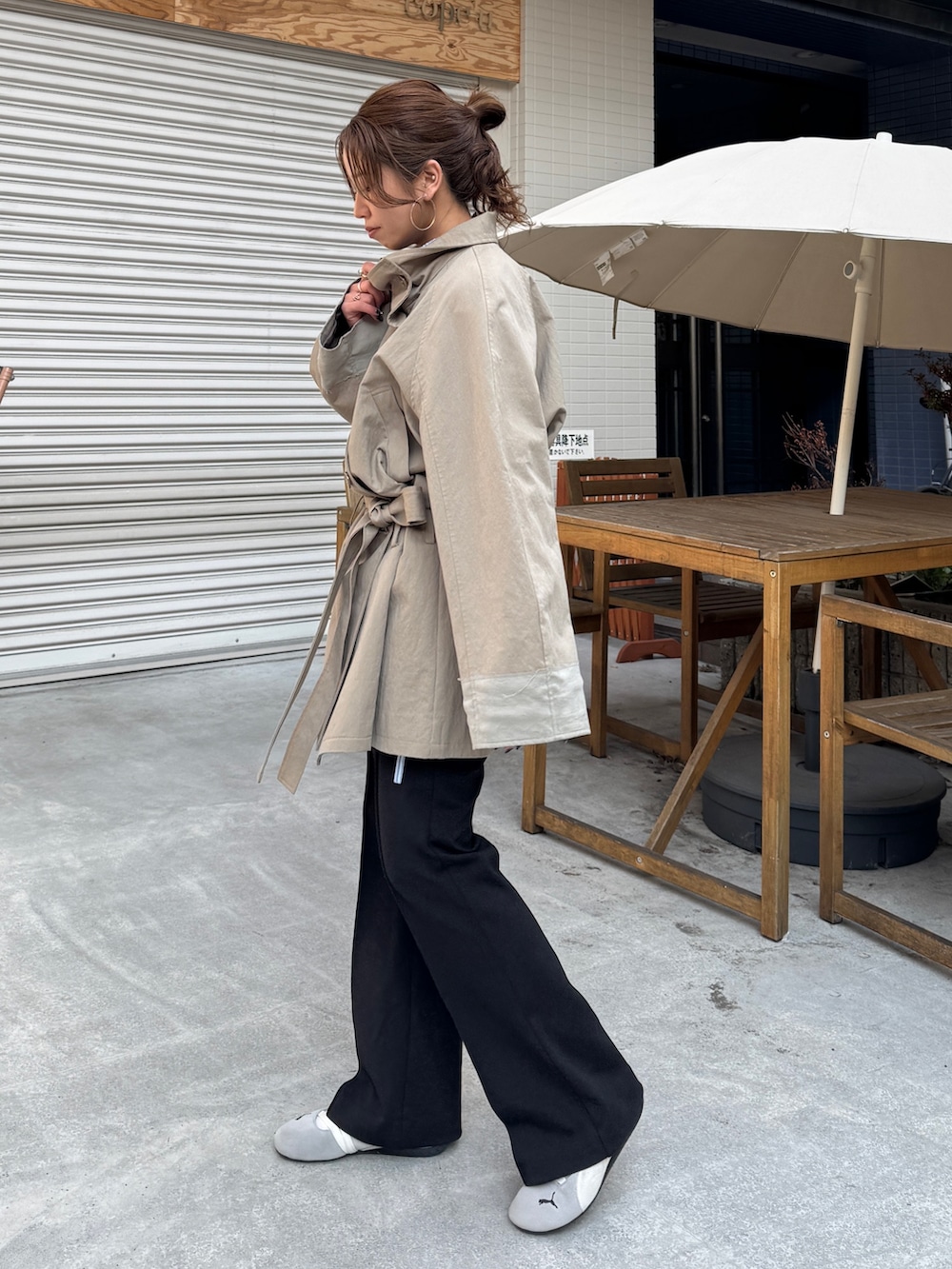 グリーン系のトレンチコート、ブラック系のその他パンツを着用したレディースの冬コーディネートの3枚目の写真