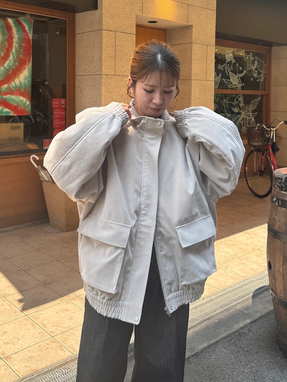 ベージュ系のブルゾン、ブラック系のデニムパンツ、ブラック系のスリッポンを着用したレディースの秋コーディネートの8枚目の写真