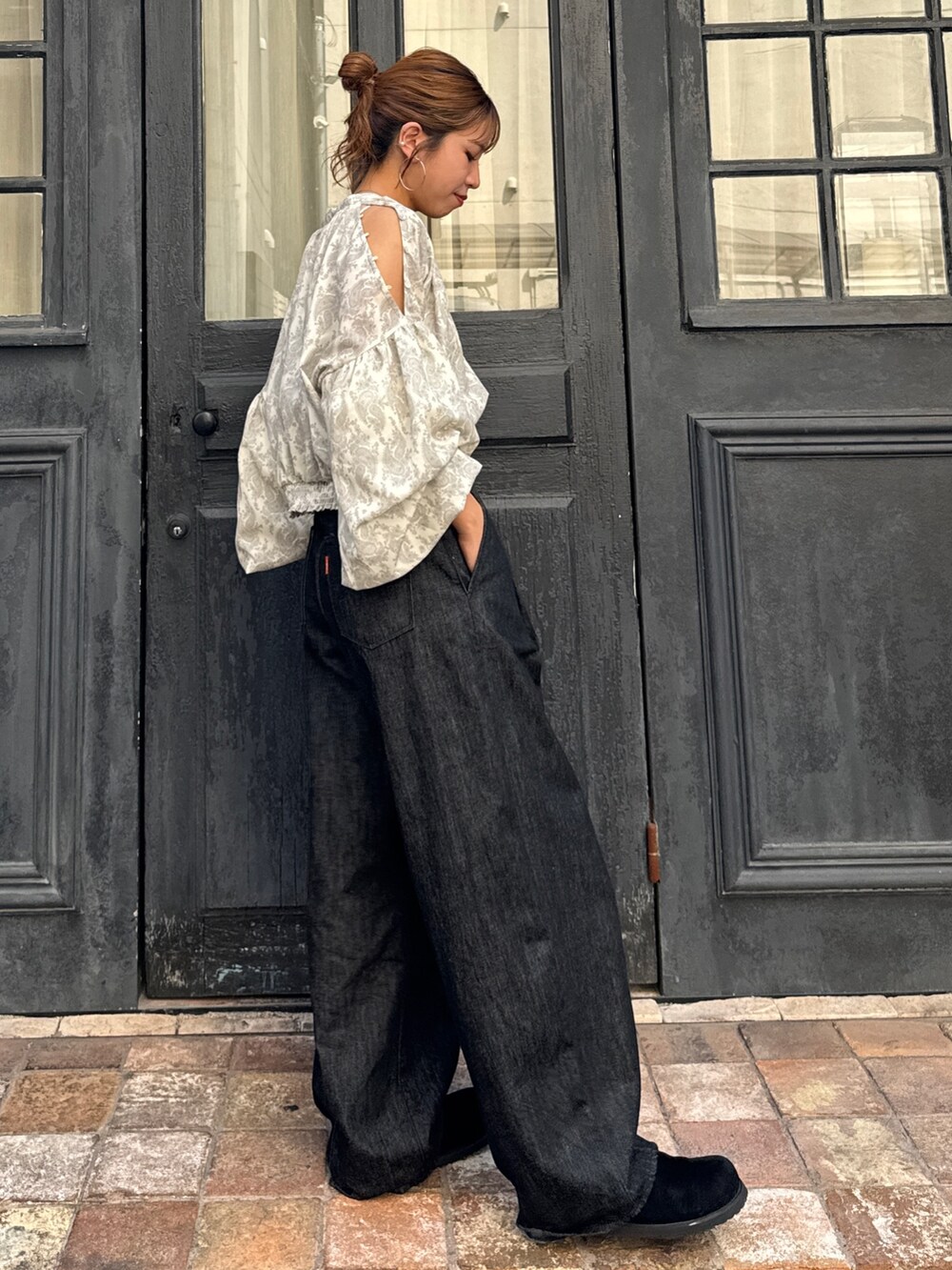 ブラック系のデニムパンツ、ブラック系のスリッポン、ホワイト系のシャツ/ブラウスを着用したレディースの秋コーディネートの3枚目の写真