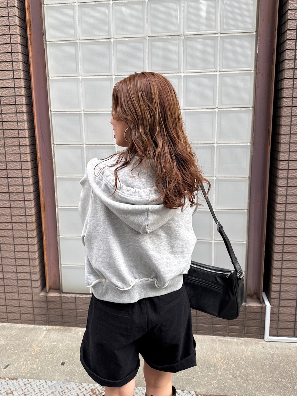 ブラック系のその他パンツ、グレー系のパーカーを着用したレディースの冬コーディネートの9枚目の写真