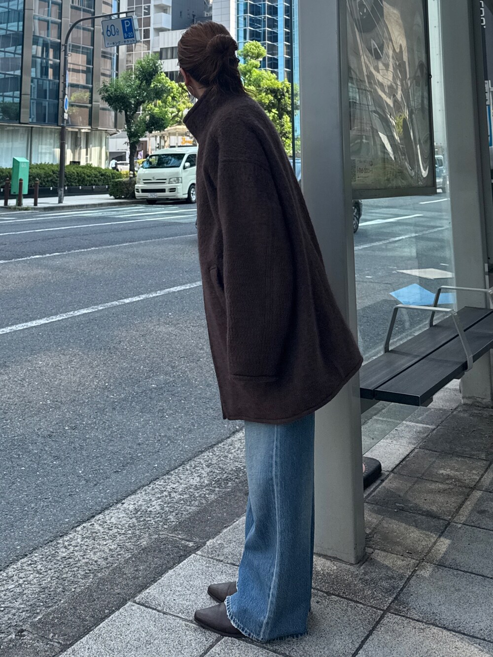 ブラウン系のダウンジャケット/コート、ブルー系のデニムパンツ、ブラウン系のブーツを着用したレディースの秋コーディネートの3枚目の写真