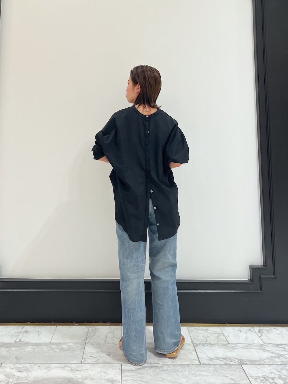 ブラック系のシャツ/ブラウス、ブルー系のデニムパンツ、イエロー系のサンダルを着用したレディースの春コーディネートの4枚目の写真