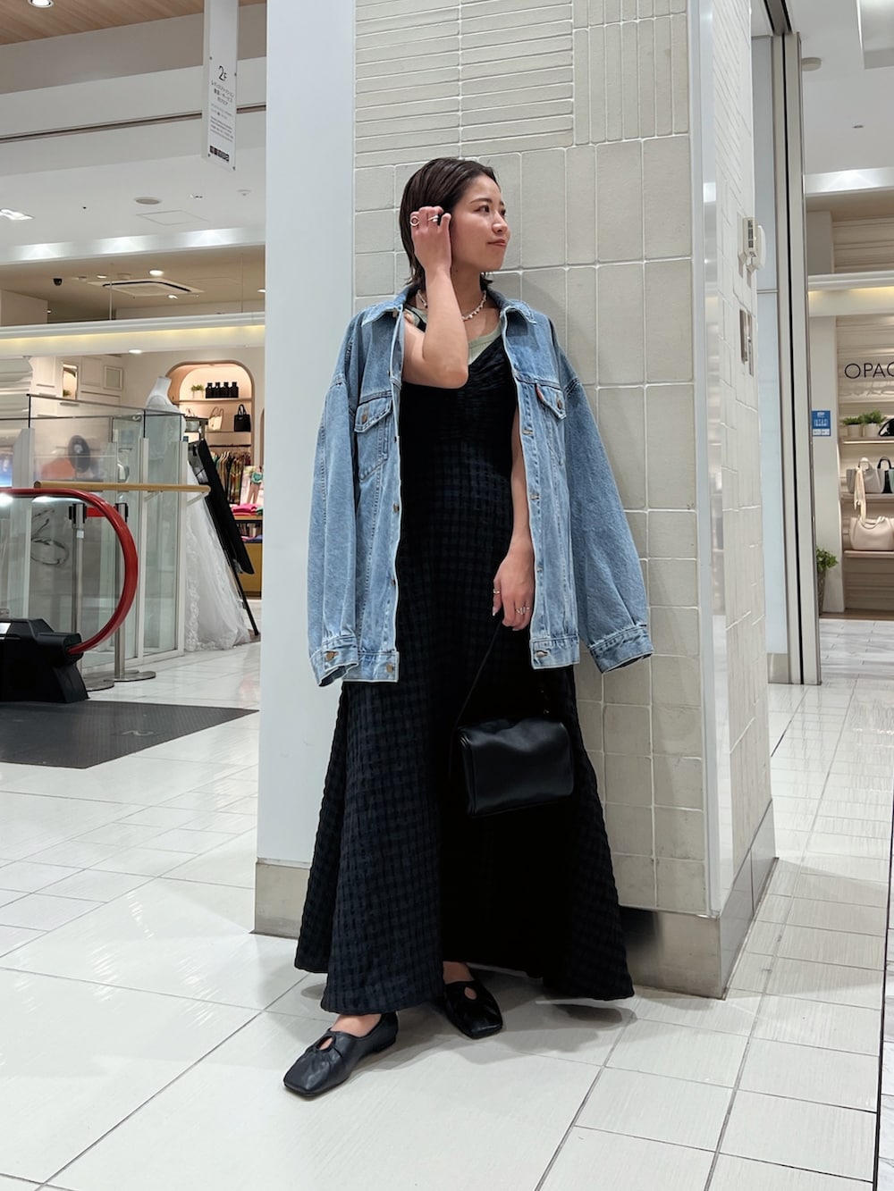 ブラック系のワンピース、グリーン系のタンクトップ、ブルー系のデニムジャケットを着用したレディースの冬コーディネートの4枚目の写真