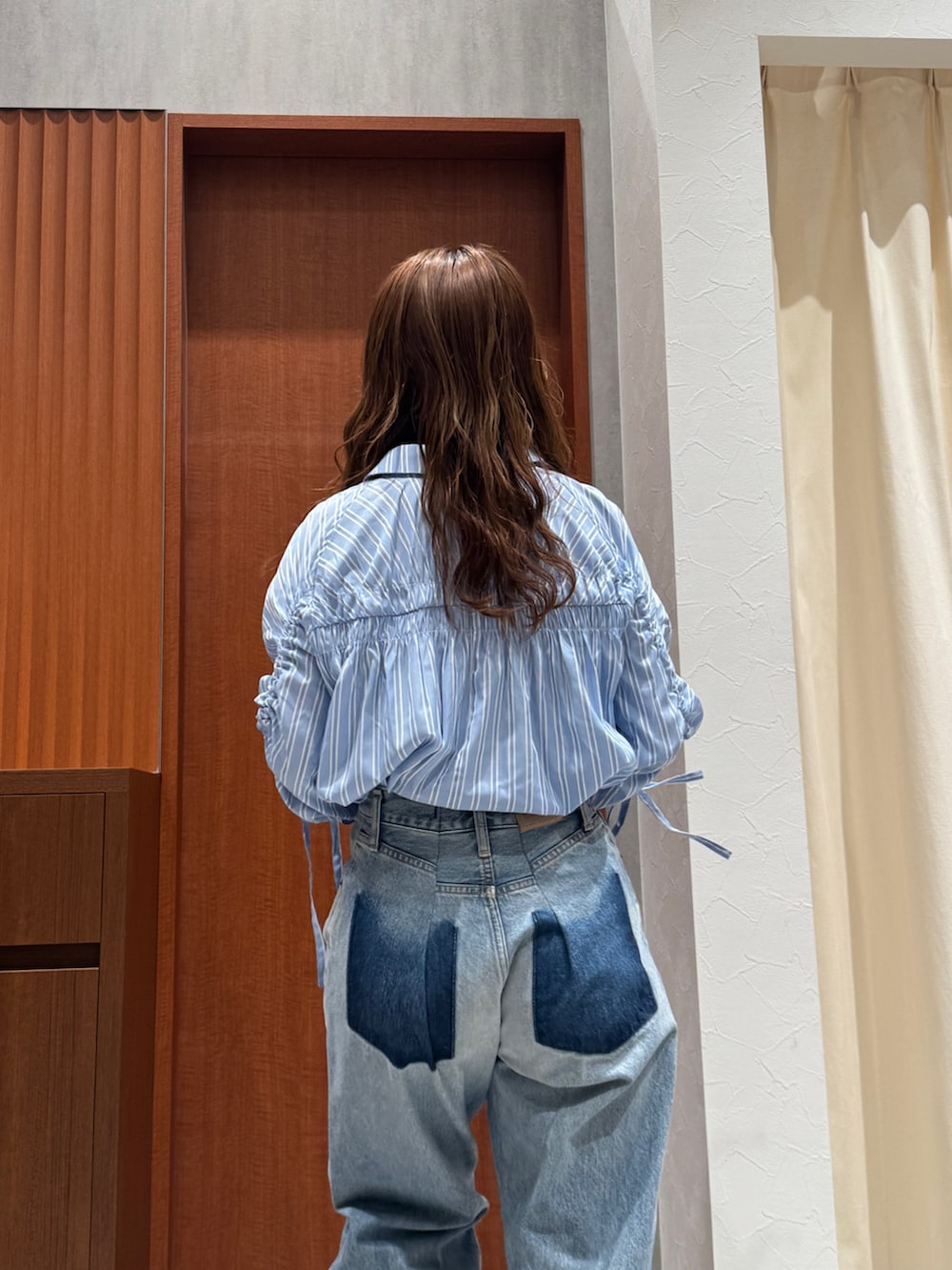 ブルー系のシャツ/ブラウス、ブルー系のデニムパンツ、ベージュ系のブーツを着用したレディースの春コーディネートの5枚目の写真