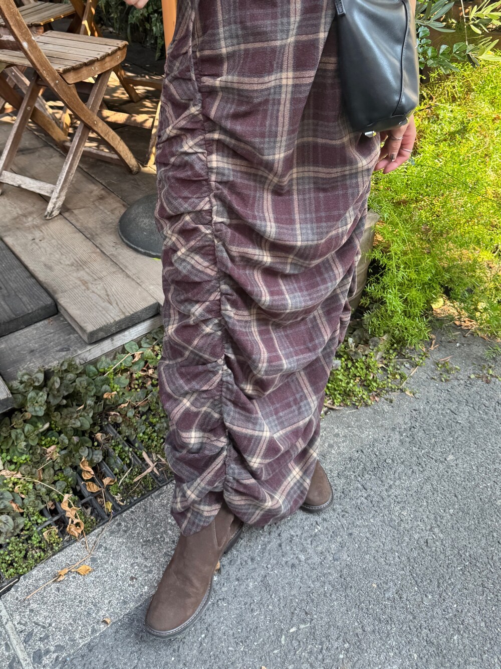 レッド系のワンピース、ブラウン系のブーツを着用したレディースの秋コーディネートの9枚目の写真