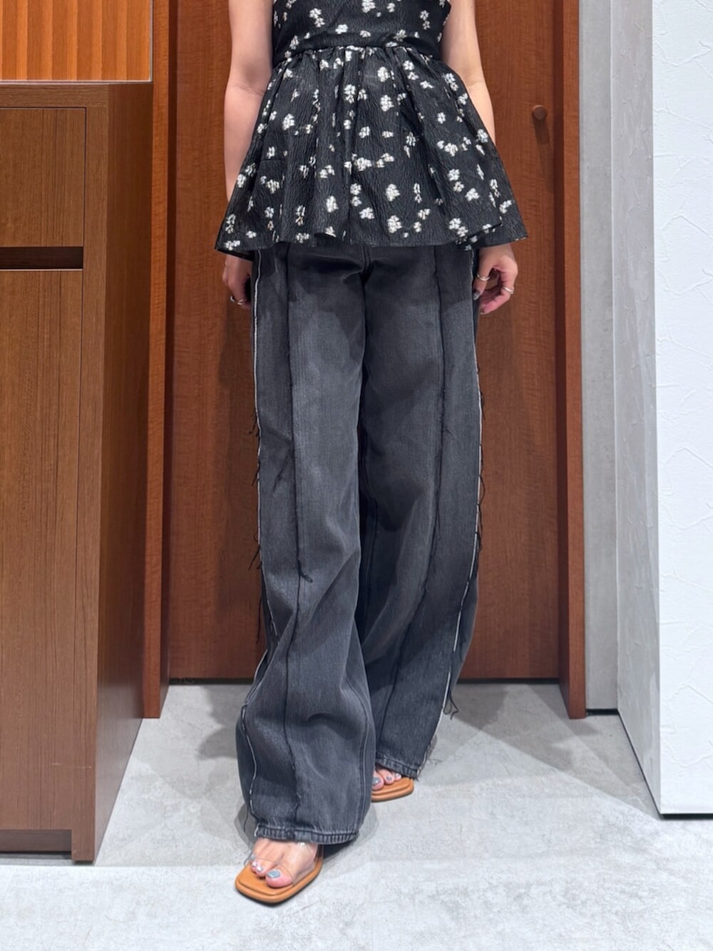 ブラック系のデニムパンツ、ブラック系のキャミソール、ホワイト系のタンクトップを着用したレディースの夏コーディネートの6枚目の写真